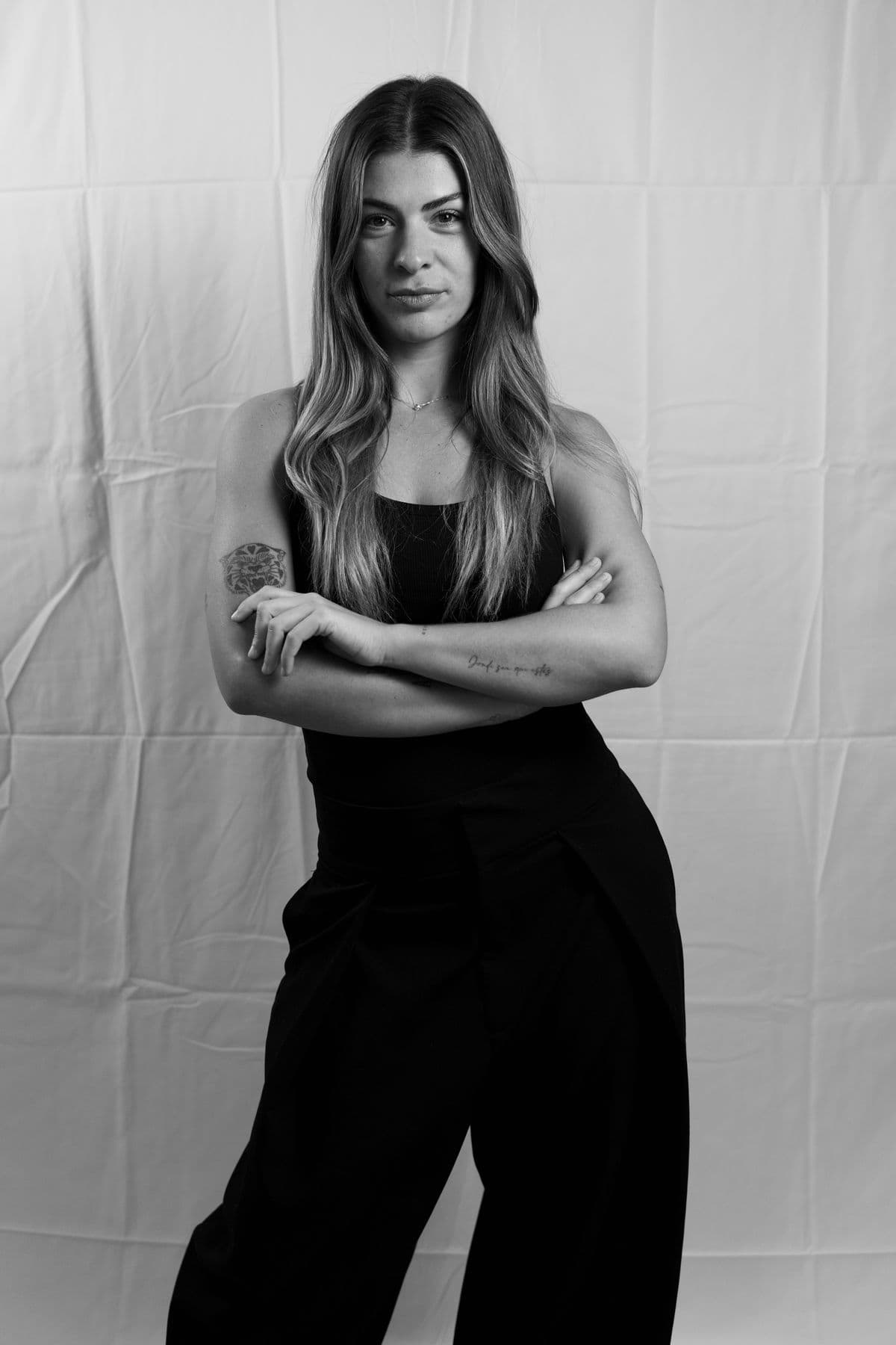 Black and white studio portrait, arms crossed
